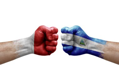 Two hands punch to each others on white background. Country flags painted fists, conflict crisis concept between malta and nicaragua