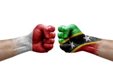 Two hands punch to each others on white background. Country flags painted fists, conflict crisis concept between malta and saint kitts and nevis