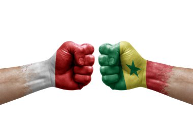 Two hands punch to each others on white background. Country flags painted fists, conflict crisis concept between malta and senegal