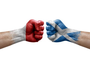 Two hands punch to each others on white background. Country flags painted fists, conflict crisis concept between malta and scotland