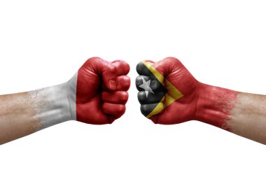 Two hands punch to each others on white background. Country flags painted fists, conflict crisis concept between malta and timor leste