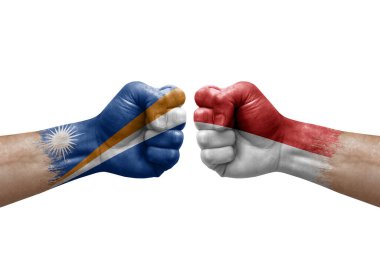 Two hands punch to each others on white background. Country flags painted fists, conflict crisis concept between marshall islands and monaco