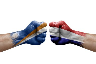 Two hands punch to each others on white background. Country flags painted fists, conflict crisis concept between marshall islands and netherlands