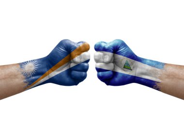 Two hands punch to each others on white background. Country flags painted fists, conflict crisis concept between marshall islands and nicaragua