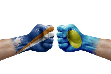 Two hands punch to each others on white background. Country flags painted fists, conflict crisis concept between marshall islands and palau