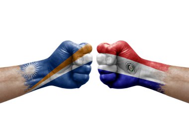 Two hands punch to each others on white background. Country flags painted fists, conflict crisis concept between marshall islands and paraguay