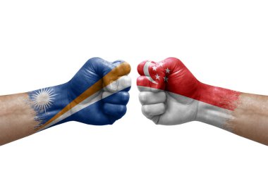 Two hands punch to each others on white background. Country flags painted fists, conflict crisis concept between marshall islands and singapore
