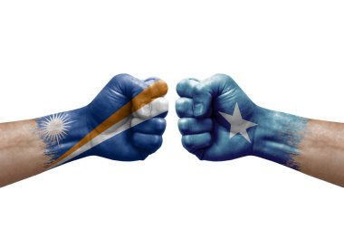 Two hands punch to each others on white background. Country flags painted fists, conflict crisis concept between marshall islands and somalia
