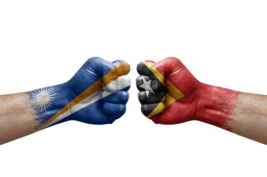 Two hands punch to each others on white background. Country flags painted fists, conflict crisis concept between marshall islands and timor leste