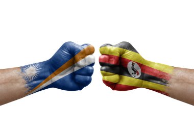 Two hands punch to each others on white background. Country flags painted fists, conflict crisis concept between marshall islands and uganda