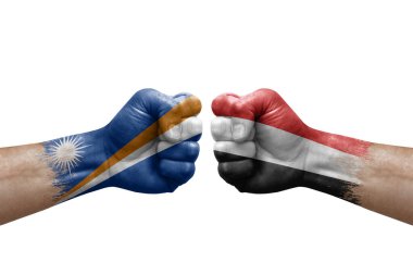 Two hands punch to each others on white background. Country flags painted fists, conflict crisis concept between marshall islands and yemen