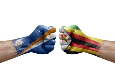 Two hands punch to each others on white background. Country flags painted fists, conflict crisis concept between marshall islands and zimbabwe