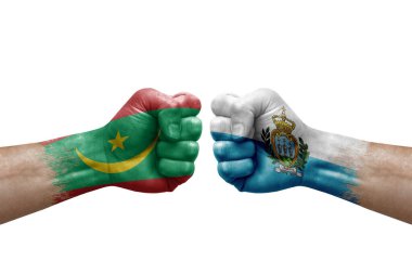 Two hands punch to each others on white background. Country flags painted fists, conflict crisis concept between mauritania and san marino