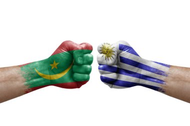 Two hands punch to each others on white background. Country flags painted fists, conflict crisis concept between mauritania and uruguay