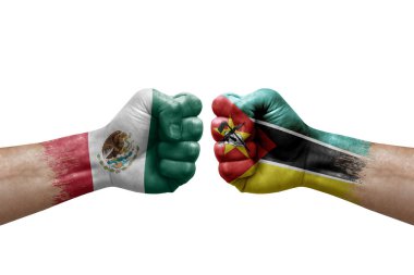 Two hands punch to each others on white background. Country flags painted fists, conflict crisis concept between mexico and mozambique