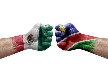 Two hands punch to each others on white background. Country flags painted fists, conflict crisis concept between mexico and namibia