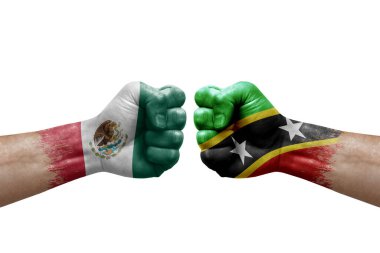Two hands punch to each others on white background. Country flags painted fists, conflict crisis concept between mexico and saint kitts and nevis