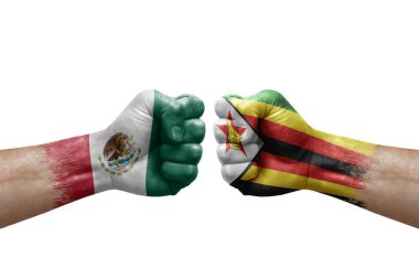 Two hands punch to each others on white background. Country flags painted fists, conflict crisis concept between mexico and zimbabwe