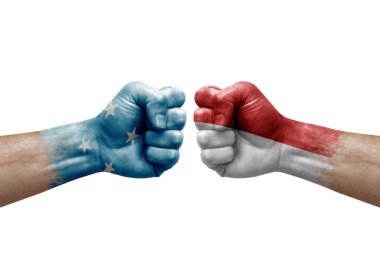 Two hands punch to each others on white background. Country flags painted fists, conflict crisis concept between micronesia and monaco