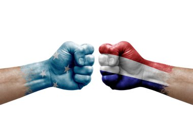 Two hands punch to each others on white background. Country flags painted fists, conflict crisis concept between micronesia and netherlands