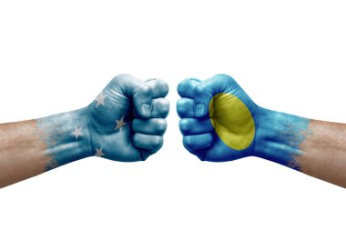 Two hands punch to each others on white background. Country flags painted fists, conflict crisis concept between micronesia and palau