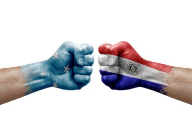 Two hands punch to each others on white background. Country flags painted fists, conflict crisis concept between micronesia and paraguay