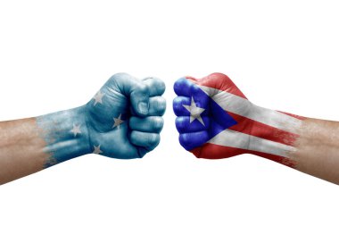 Two hands punch to each others on white background. Country flags painted fists, conflict crisis concept between micronesia and puerto rico