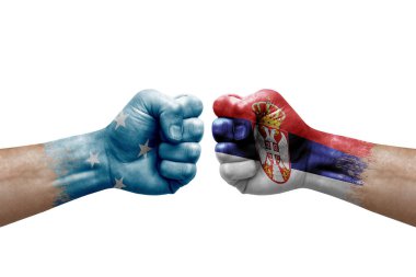 Two hands punch to each others on white background. Country flags painted fists, conflict crisis concept between micronesia and serbia