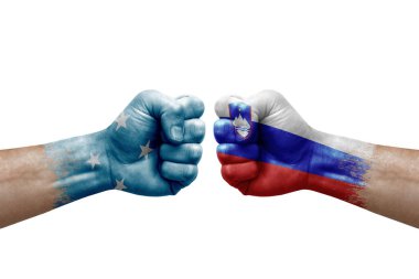 Two hands punch to each others on white background. Country flags painted fists, conflict crisis concept between micronesia and slovenia
