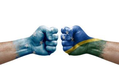 Two hands punch to each others on white background. Country flags painted fists, conflict crisis concept between micronesia and solomon islands