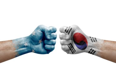 Two hands punch to each others on white background. Country flags painted fists, conflict crisis concept between micronesia and south korea