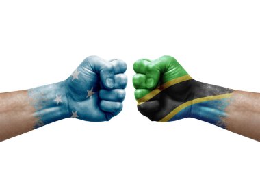 Two hands punch to each others on white background. Country flags painted fists, conflict crisis concept between micronesia and tanzania