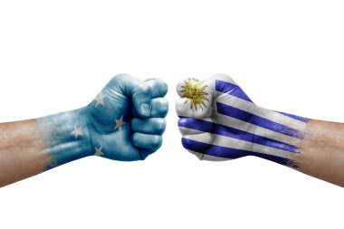 Two hands punch to each others on white background. Country flags painted fists, conflict crisis concept between micronesia and uruguay