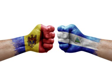 Two hands punch to each others on white background. Country flags painted fists, conflict crisis concept between moldova and nicaragua