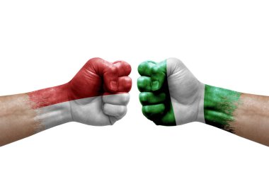 Two hands punch to each others on white background. Country flags painted fists, conflict crisis concept between monaco and nigeria