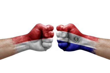Two hands punch to each others on white background. Country flags painted fists, conflict crisis concept between monaco and paraguay