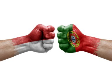 Two hands punch to each others on white background. Country flags painted fists, conflict crisis concept between monaco and portugal