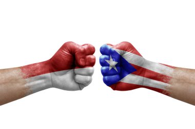 Two hands punch to each others on white background. Country flags painted fists, conflict crisis concept between monaco and puerto rico
