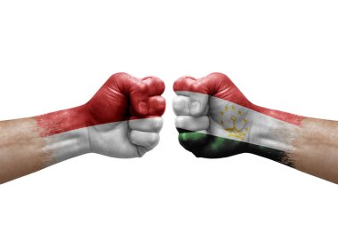 Two hands punch to each others on white background. Country flags painted fists, conflict crisis concept between monaco and tajikistan