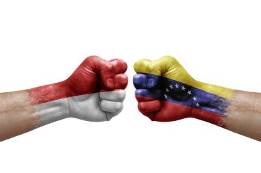 Two hands punch to each others on white background. Country flags painted fists, conflict crisis concept between monaco and venezuela