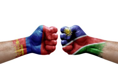 Two hands punch to each others on white background. Country flags painted fists, conflict crisis concept between mongolia and namibia