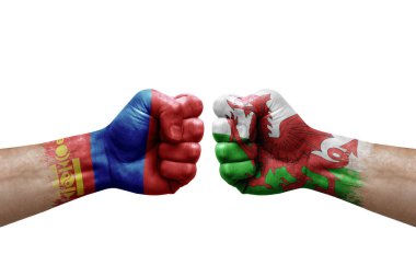 Two hands punch to each others on white background. Country flags painted fists, conflict crisis concept between mongolia and wales