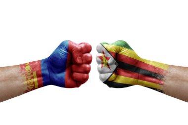 Two hands punch to each others on white background. Country flags painted fists, conflict crisis concept between mongolia and zimbabwe