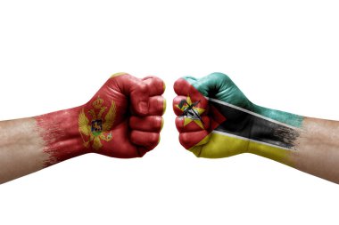 Two hands punch to each others on white background. Country flags painted fists, conflict crisis concept between montenegro and mozambique