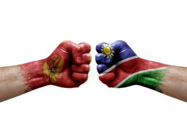 Two hands punch to each others on white background. Country flags painted fists, conflict crisis concept between montenegro and namibia