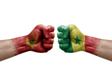 Two hands punch to each others on white background. Country flags painted fists, conflict crisis concept between montenegro and senegal