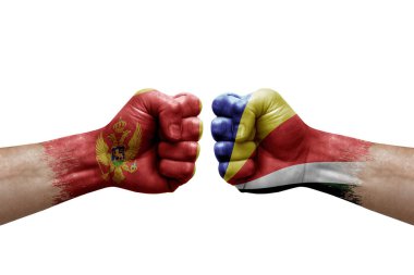 Two hands punch to each others on white background. Country flags painted fists, conflict crisis concept between montenegro and seychelles