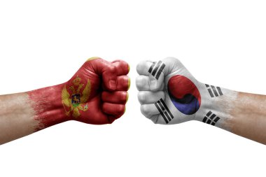Two hands punch to each others on white background. Country flags painted fists, conflict crisis concept between montenegro and south korea