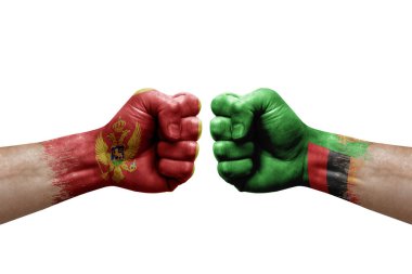 Two hands punch to each others on white background. Country flags painted fists, conflict crisis concept between montenegro and zambia