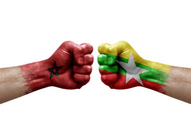 Two hands punch to each others on white background. Country flags painted fists, conflict crisis concept between morocco and myanmar